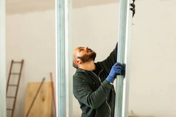 Arbeiter baut eine Gipskartonwand. — Stockfoto