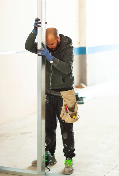 Lavoratore costruisce un muro di cartongesso . — Foto Stock