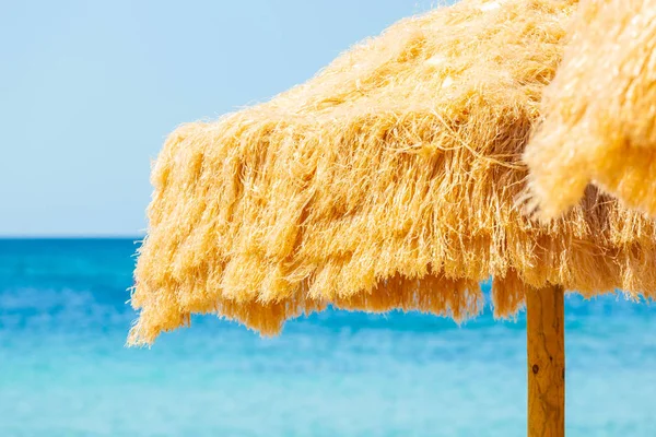 Playa hermosa sombrillas de paja y mar turquesa . — Foto de Stock