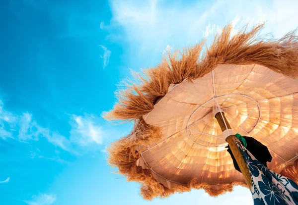 Vue de dessous de beaux parasols au toit de chaume sur la plage . — Photo