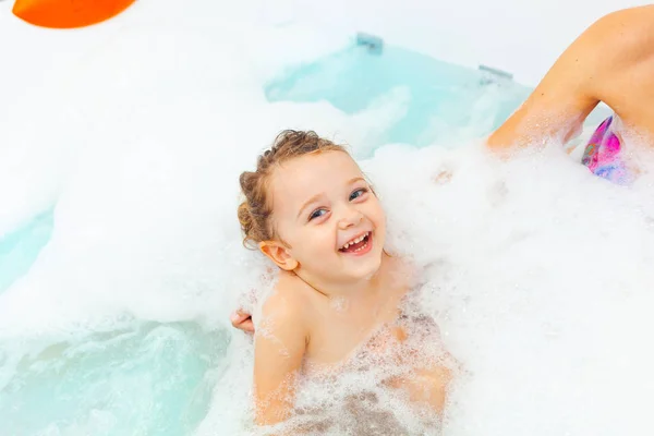 Kleines Mädchen nimmt ein Bad in einer Hydromassage-Badewanne. — Stockfoto