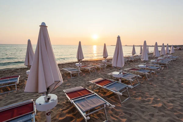 Parasols et chaises fermées au coucher du soleil . — Photo