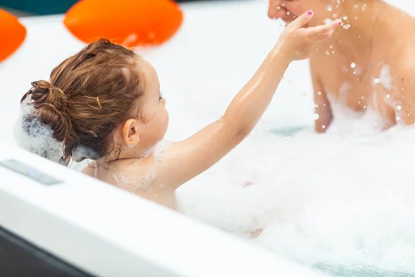 Little girl takes a bath in a hydromassage bathtub. — Stock Photo, Image