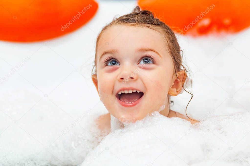 Little girl takes a bath in a hydromassage bathtub.
