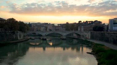 Vatikan'daki Aziz Petrus Bazilikası'nın gün batımı manzarası ve Castel Sant'Angelo'daki Ponte Sant'Angelo Melekler Köprüsü ve Roma İtalya'daki Tiber Nehri