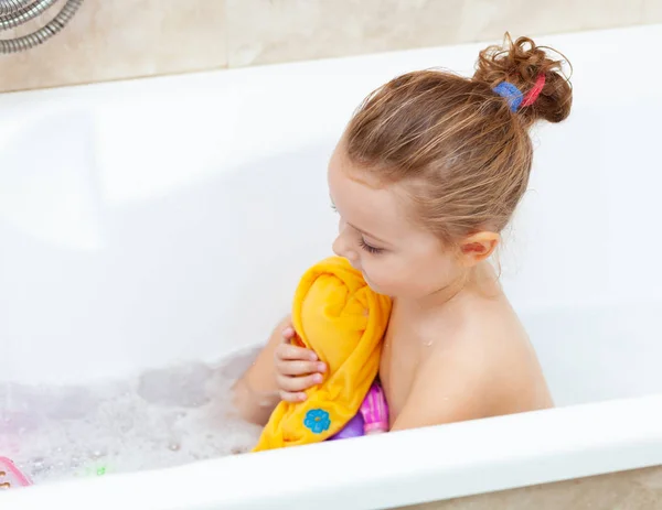 Female toddler takes a bath and plays with plastic toys — Stock Photo, Image