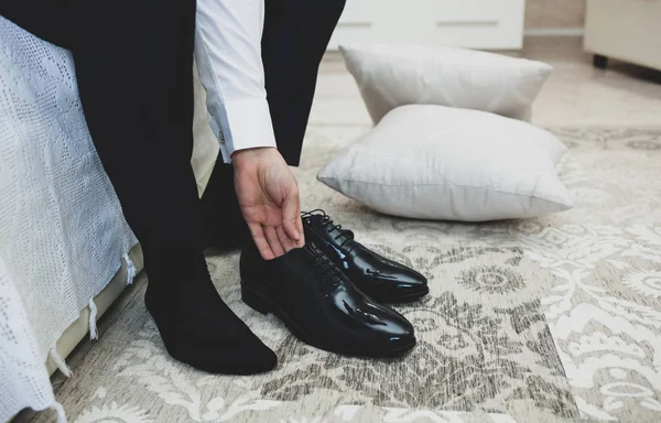 El hombre de traje ata los cordones de los zapatos negros clásicos elegantes . —  Fotos de Stock