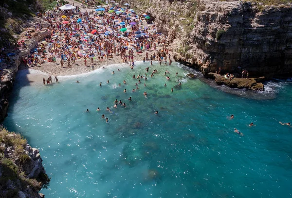 ポリニャーノ マーレ イタリア 2014年8月15日 美しいビーチでリラックスして泳ぐ人々ラマ モナシール 白い小石の入り江は岩壁の間にあり 海の洞窟がある透明な水で覆われています — ストック写真