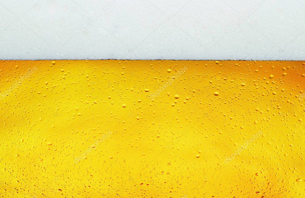 Close up background texture of lager beer with bubbles and froth in glass.