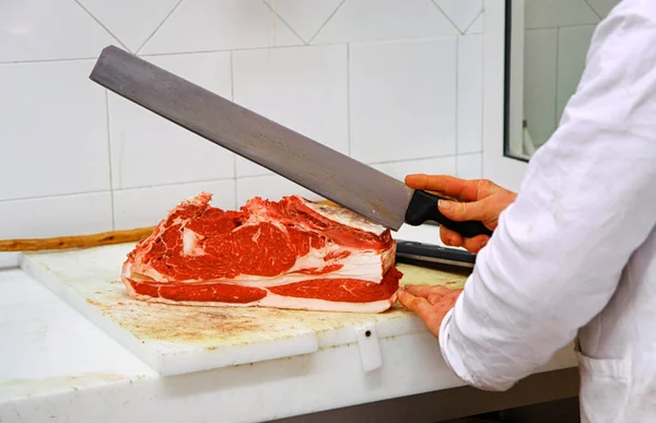 在肉铺里 肉铺把一块红牛肉切成薄片 — 图库照片