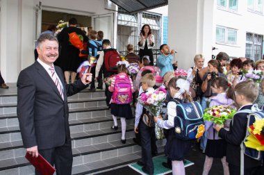 Moscow - September 1, 2011: Children go to the first class at the day of knowledge. Public-event. clipart