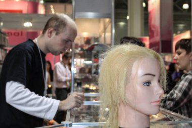 Moskova-Nisan 19: Kimliği belirsiz peruk profesyonel kozmetik ve Güzellik Salonu ekipman Intercharm 19 Nisan 2012 tarihinde Moskova'da Uluslararası fuarında satıyor.