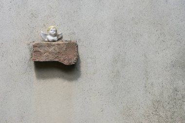 Küçük melek heykel tuğla duvar üzerine yerleştirilir. Metin kopyalama yeri olan yer.