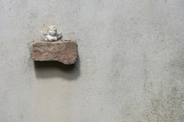 Küçük melek heykel tuğla duvar üzerine yerleştirilir. Metin kopyalama yeri olan yer.