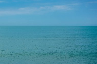 Mavi deniz, ufuk ve beyaz bulutlar gökyüzü arka plan olarak
