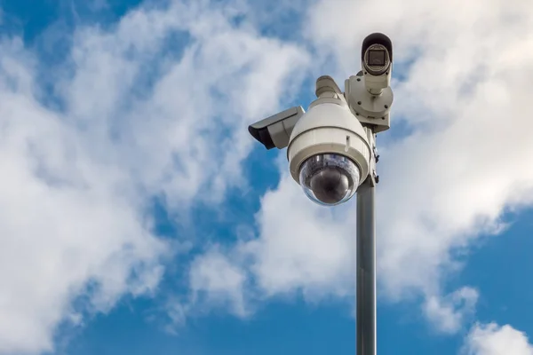 Cámaras de seguridad CCTV en polo en el cielo azul con fondo de nubes blancas — Foto de Stock