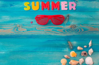 Top view summer holidays background concept with louvered shades and seashells on blue wooden table clipart