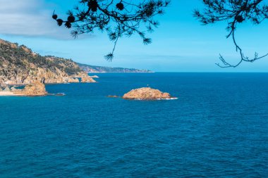 Deniz sahilinin güzel manzarası. Denizde Katalonya bayrağı ile Rocks ada. Tossa de Mar, Costa Brava, İspanya.