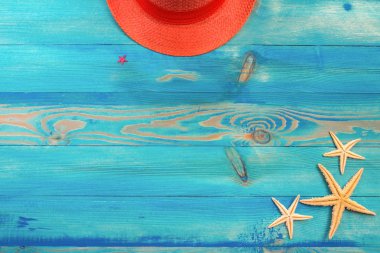 Mavi boyalı vintage ahşap doku üzerinde yaşayan mercan renkli şapka ve denizyıldızı üst görünümü. Düz döşeme, kopyalama alanı.