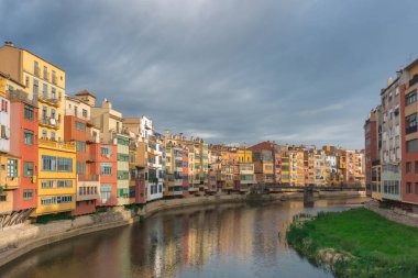 Renkli sarı ve turuncu evler Onyar Nehri'nde suya yansıdı. Girona, Katalonya, İspanya.