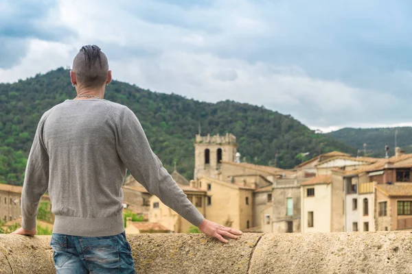 Hombre mirando a la vieja ciudad medieval de España Besalu desde el puente — Foto de Stock