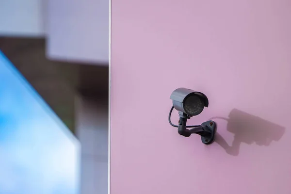 Cámara CCTV en la pared rosa en la ciudad moderna — Foto de Stock