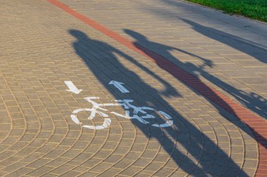 Gün batımında bisiklet şeridinde bisikletçiler gölgeler