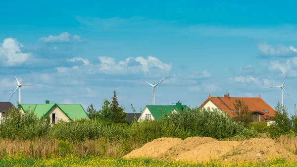 Wind turbines en huizen in een gebied op blauwe hemel achtergrond. Concept schone en hernieuwbare energie — Stockfoto