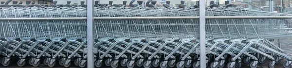 Süpermarketin yakınındaki boş alışveriş arabaları. Halka açık yerlerde alışveriş arabalarını kapatın. Markete yakın alışveriş arabaları