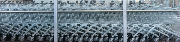 Row of empty shopping cart near supermarket. Close up shop trolleys in public place. Shopping carts near store