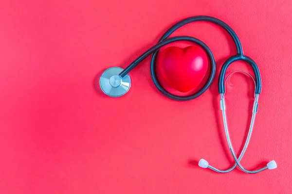 Medical stethoscope with red heart on red background. Flat lay of stethoscope and heart and isolated on red background. Mockup for Valentines day with copy space. Healthcare and cardiology concept.