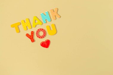 Kırmızı kalp ve kelimeler sarı arkaplandaki renkli ahşap harfler için teşekkür ederim. Yazıt ve kalbe teşekkür ederim. Takdir, minnettarlık ve aşk konsepti.