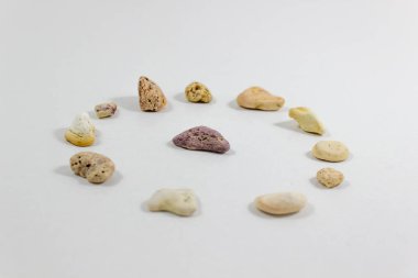 Geniş perspektif plaj beyaz arka plan üzerinde toplanan birkaç dairesel konumlandırılmış renkli taş vurdu. Fotoğraf Izmir'aldı.