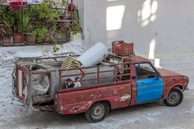 Eski kırmızı pick-up perspektif temiz atış bina yakın takip. Lesvos, Yunanistan içinde fotoğraf aldı.