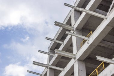 Bakış açısı yeni bir betonarme inşaatı vurdu ve açık mavi gökyüzü ile bağlantılı bina metal kirişler