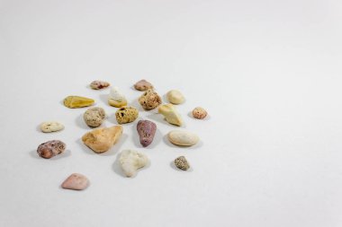 Geniş perspektif plaj beyaz arka plan üzerinde toplanan çeşitli renkli taşların vurdu. Fotoğraf Izmir'aldı.