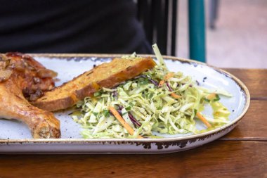 Perspektif ateş beyaz plaka üzerinde taze salata ahşap masa