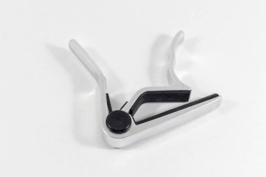 Beyaz arka plan ile metal yansıtıcı gitar capo temiz en iyi ateş