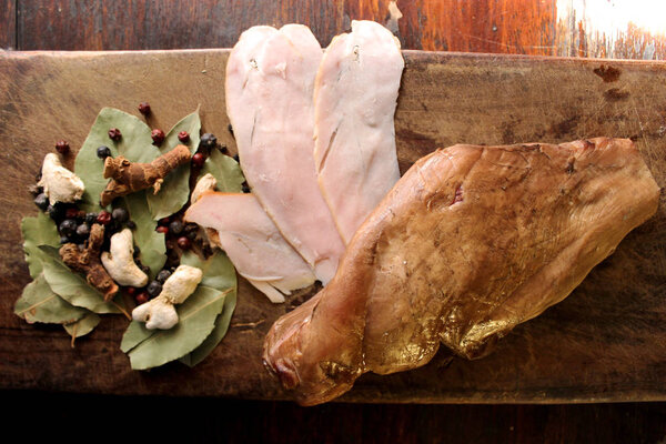 Крупный план домашнего приготовления вкусного копченого мяса индейки ручной работы на деревянной поверхности
