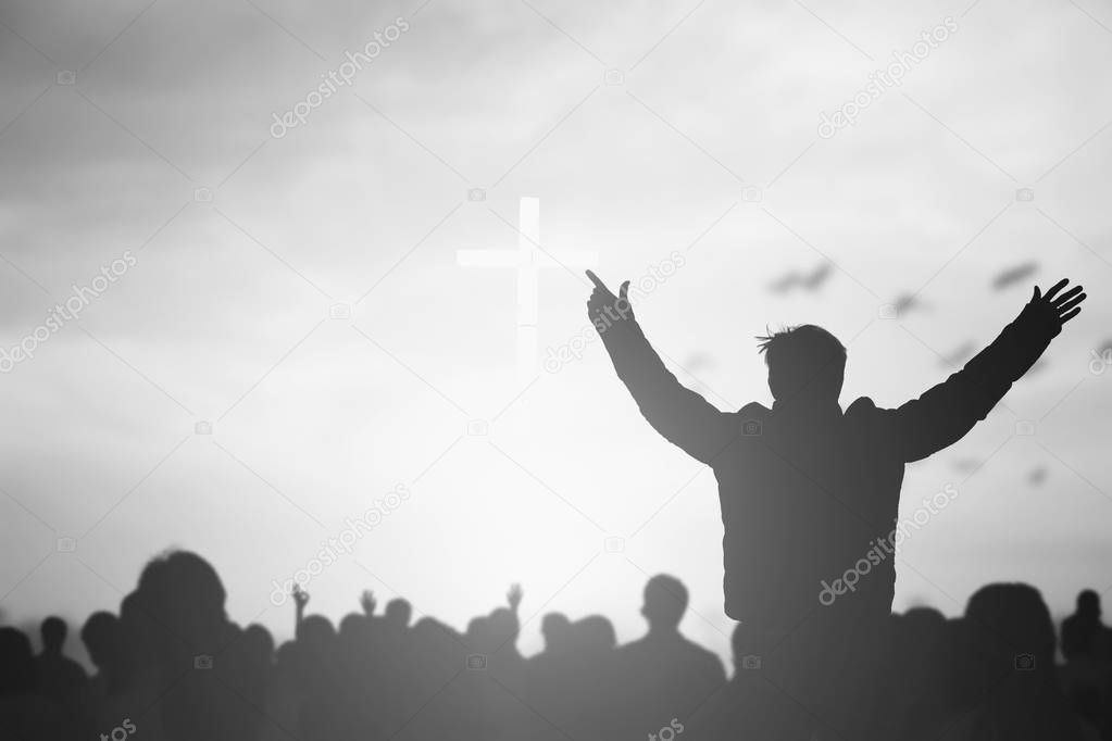 Silhouette of Christian prayers raising hand while praying to the Jesus