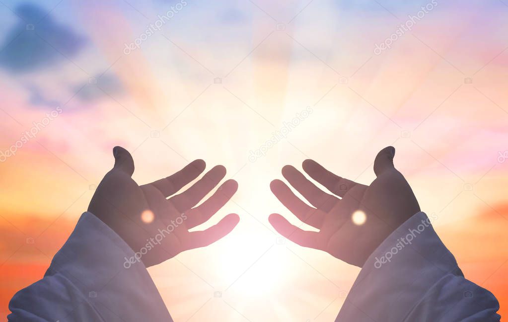 Ramadan kareem concept: Silhouette hands of God over blurred sunset background