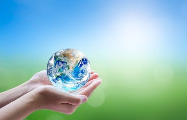 Dünya 'yı bulanık arka planda tutan eller, dünya kavramını kurtarır.