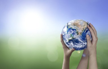 Dünya 'yı bulanık arka planda tutan eller, dünya kavramını kurtarır.