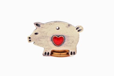 Seramik domuzcuk sikkeleri üzerinde oturuyor. Beyaz arka plan üzerinde izole.