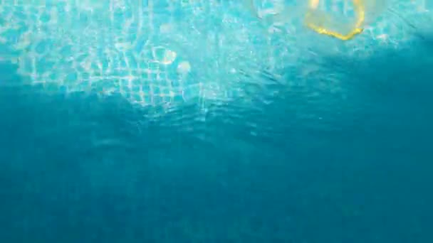 Ondas chispeantes extendiéndose sobre la superficie de agua azul — Vídeos de Stock