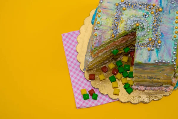 colored cut cake on a yellow background
