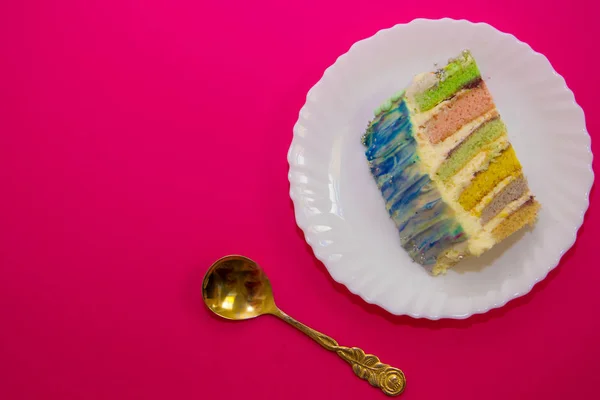 Pastel con un relleno de arco iris, sobre un fondo carmesí — Foto de Stock