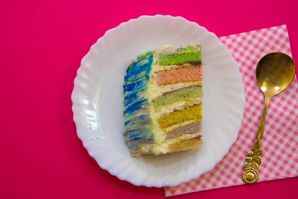 Pastel con un relleno de arco iris, sobre un fondo carmesí — Foto de Stock