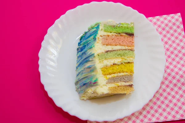 Торт с радужной начинкой, на малиновом фоне — стоковое фото