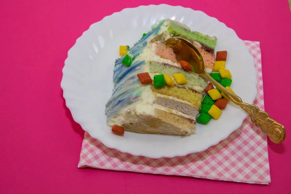 Pastel cortado de color sobre un fondo de frambuesa — Foto de Stock